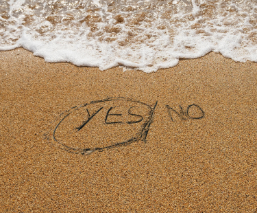 Yes/No written in the sand, with Yes circled