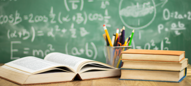 chalkboard with formulas and writing, books, school supplies