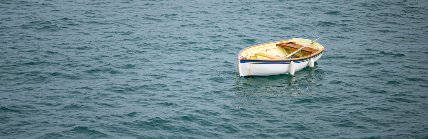 A single wooden rowboat floating on calm water, surrounded by soft, muted tones, symbolizing drift off course.