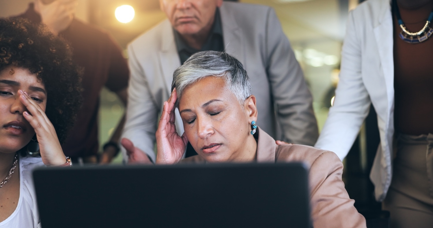 Frustrated woman surrounded by her concerned team